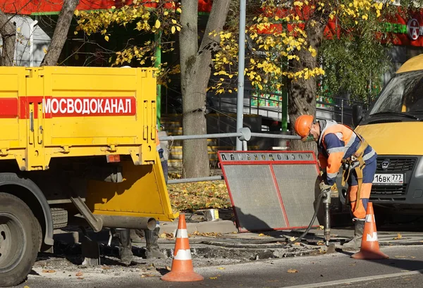 モスクワ ロシア連邦 Oktober 2012 ダンプ トラック解体アスファルトとモスクワで削岩機でオレンジのレーシング スーツの労働者 — ストック写真