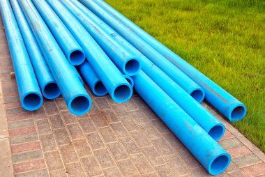 Bir taş kaldırım üzerinde plastik su boruları.
