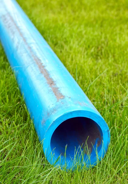 緑の芝生の上のプラスチックの水道管 — ストック写真