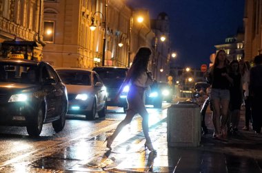 Moskova, Rusya - Haziran, 2018: Kız yolun gece görünümü yağmur sonra geçiyor..