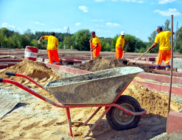 Carretilla Con Hormigón Lugar Construcción Los Trabajadores Uniforme Imagen Horizontal — Foto de Stock