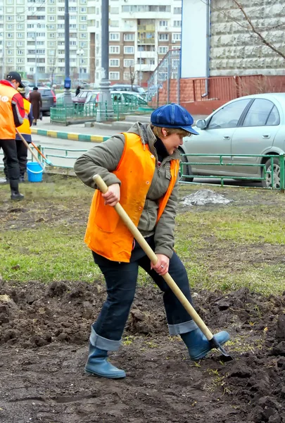莫斯科 2016年9月 一名身穿橙色背心 拿着铲子的妇女在地上挖土 城市街道的公共清洁 — 图库照片
