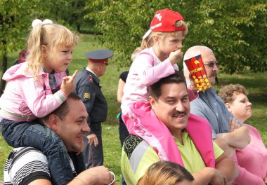 Moskova, Eylül 2016: Babalarının omuzlarında kızlar. Şehir günü sokak performansı.