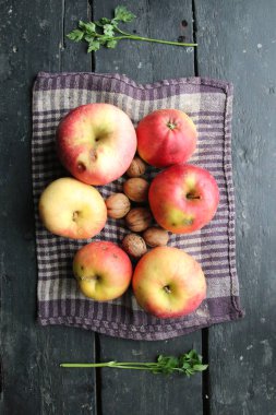 Apples, nuts and rooster are on the old vintage table