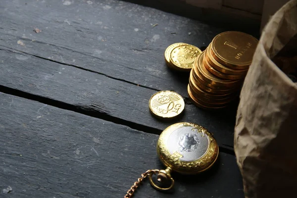 Investiční nápad, zlaté mince na vintage tabulka a starožitné kapesní hodinky — Stock fotografie