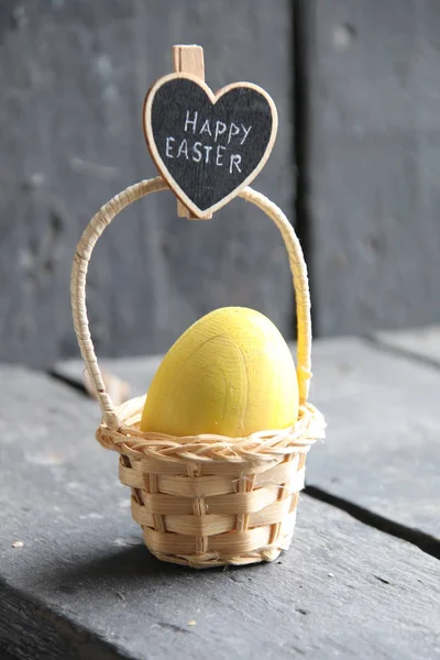 Frohe Ostern, ein Schild mit einer Inschrift und einem Ei im Korb — Stockfoto