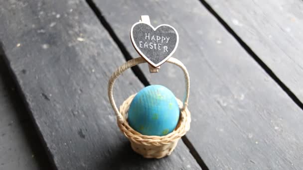 Ευτυχισμένο Πάσχα πινακίδα με και ένα αυγό σε ένα καλάθι — Αρχείο Βίντεο