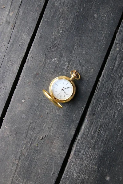 Idea de gestión del tiempo. Reloj de bolsillo dorado en una mesa vintage . — Foto de Stock