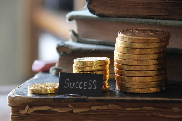Etiqueta de sucesso e moedas de ouro no fundo de livros vintage . — Fotografia de Stock
