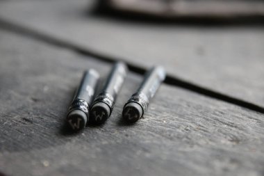 Vay canına. Kalemler, üzerinde yazı olan eski bir masanın üzerinde..