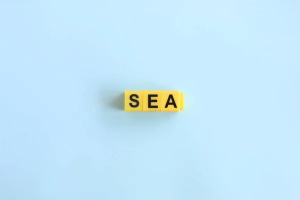 Concepto de mar, letras en letras amarillas sobre un fondo azul — Foto de Stock