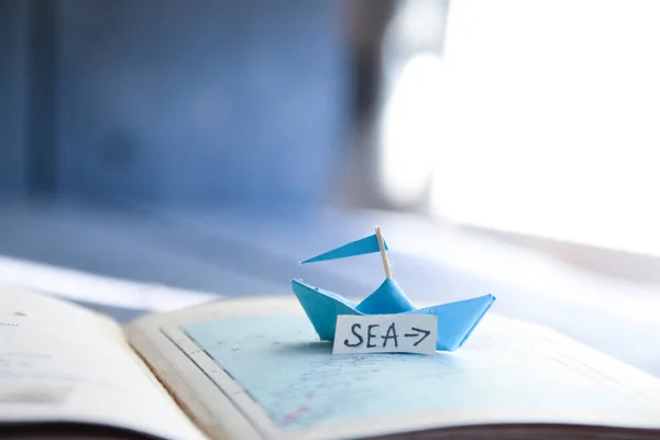 Meeresgedanke. Papierboot auf der Karte und Inschrift. — Stockfoto