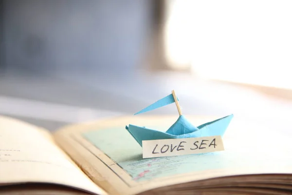 Love Sea. Paper boat on the map and inscription. — Stock Photo, Image