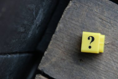 Large question mark on a wooden background..