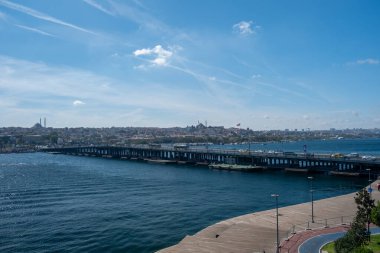 Karaky 'den İstanbul' a uzanan Unkapan Köprüsü ve tarihi siluetine sahip Golden Horn rıhtımında camiler, mavi sular ve dramatik bulutlar, Türkiye
