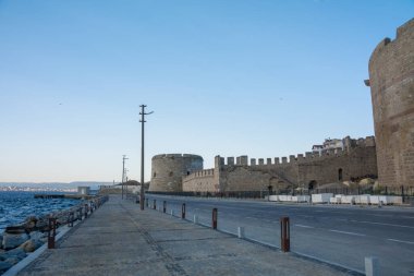 Türkiye 'deki Anakkale Kalesi duvarları ve Çanakkale Boğazı rıhtımı, deniz manzaralı tarihi Osmanlı tahkimatı ve kıyı karayolu altyapısı