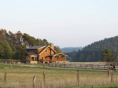 Çiftlikteki ahşap bir kulübenin etrafındaki ahşap çitler.
