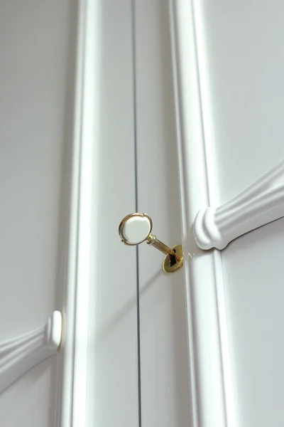 Närbild av vit garderob med guld nyckel Stockbild
