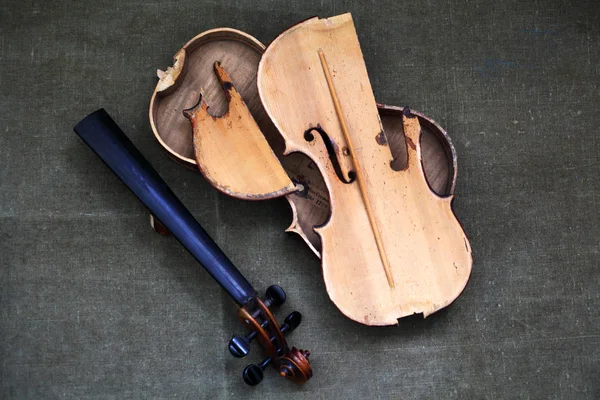 Broken old violin lying awaiting repair