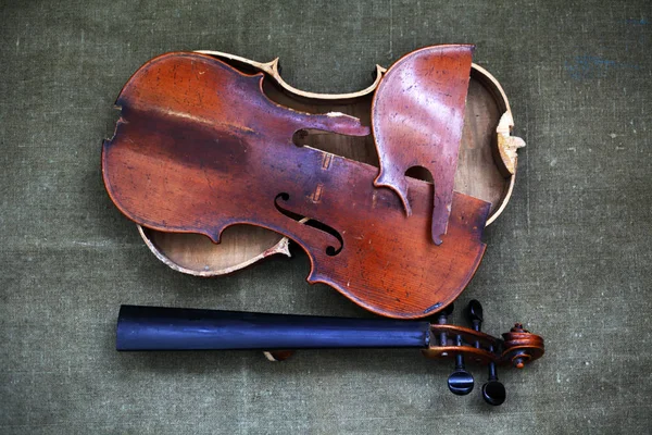 Broken old violin lying awaiting repair