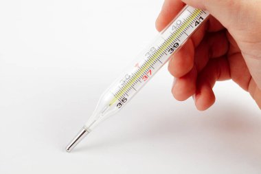 Bir çocuğun elinde tıbbi termometre, beyaz arka plan, yakın plan.
