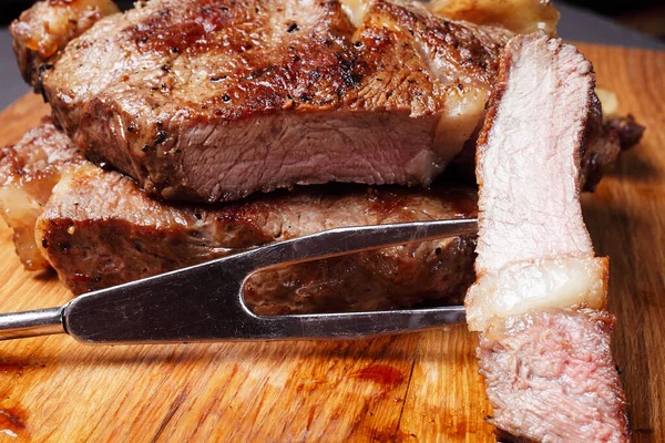 Kesme tahtasında ızgara biftek, yakın plan.