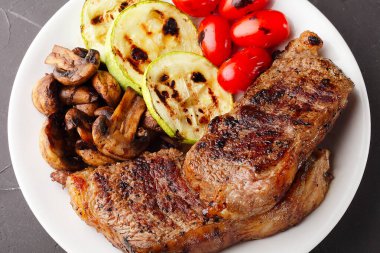 Sebze ve mantarlı mermer biftekler, seçici odaklanma, yakın çekim, üst görüş.