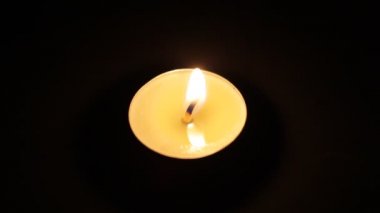 Yanan bir mum. Karanlıkta bir Noel mumu yanıyor.