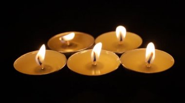 Beş yanan mum. Noel mumları karanlıkta yanar. Odaklanma ön planda, mumlar odak dışı..