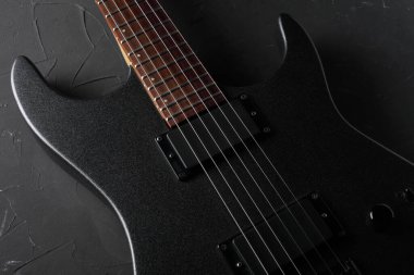 Koyu beton arka planda gri elektro gitar yakın plan.
