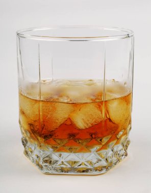 Beyaz arka planda buzlu viski, yakın plan.