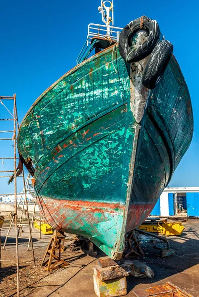 Repairs on the bow of a fishing boat in dry dock at the port of Essaouira in Morocco