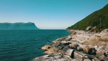 Anakara boyunca kayalık kıyılarda dağlar ve deniz arka planda, Sula, Kaarsteinen, Mauseidvaag, More og Romsdal, Norveç 2020 (4K)