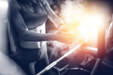 Bir kız ile bir halter egzersiz başlamadan önce ellerini alkışlar Close-up. Kavram fitness, halter. boşaltmak