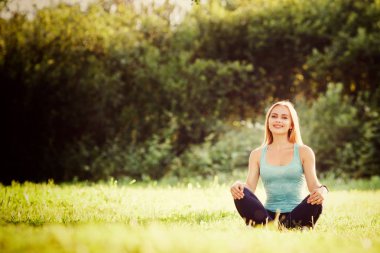 Genç kız parkta yoga yapan