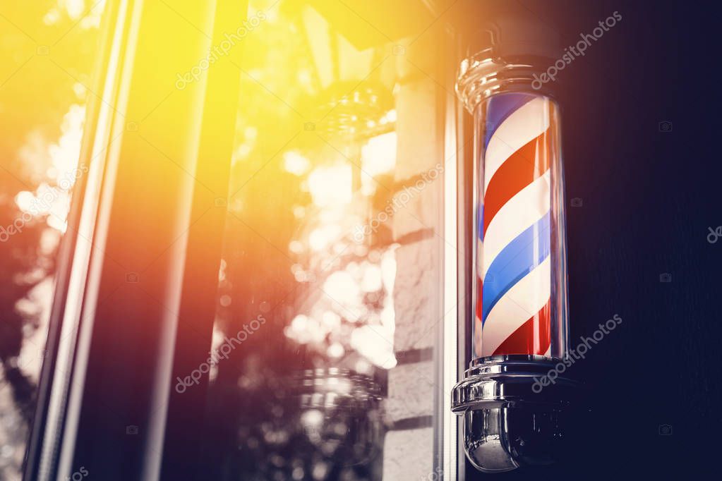 Barber shop pole at entrance of the window. background is dark. copyspace