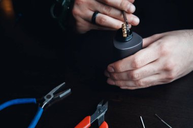 Erkek usta bir coyle yükler. Sarmal elektronik Evaporatör ve sigara için. Vape, vaping. Kerpetenler, Tel, fichral, bobin, tornavida