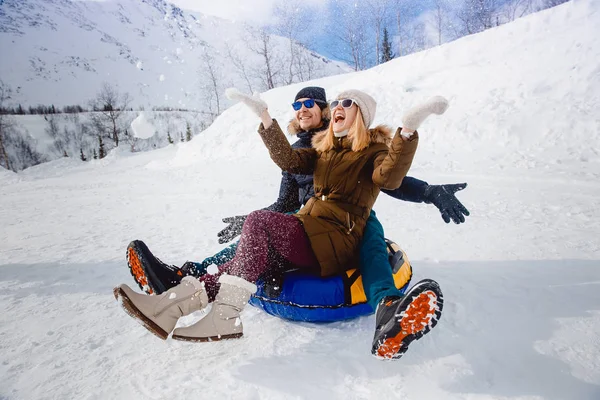 Gente feliz en el tubo al aire libre en las montañas en invierno nieve — Foto de Stock