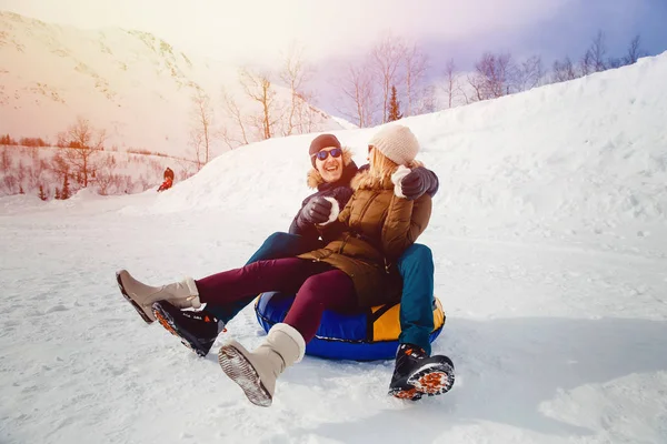 Happy people on tube outdoors in mountains in winter snow — Stock Photo, Image