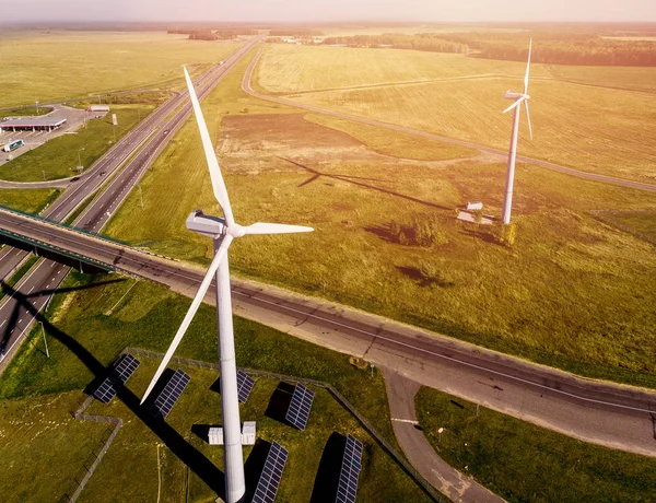 Haut VUE de la route passant près des parcs éoliens et des panneaux solaires au milieu du champ vert — Photo