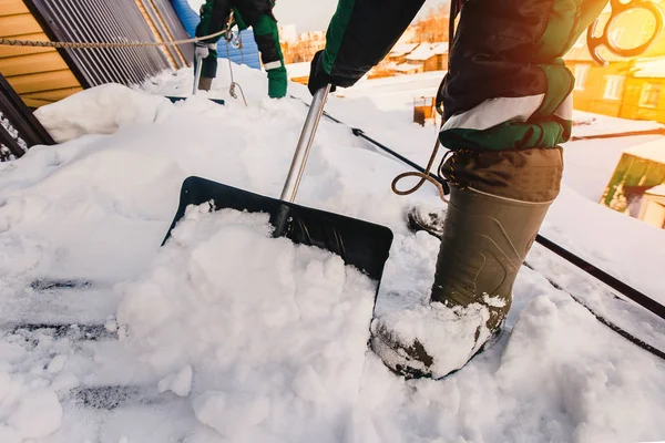 Squadra di operai maschi tetto pulito di costruzione da neve con pale — Foto Stock