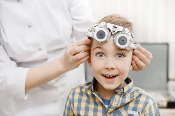 Sourire enfant garçon dans les lunettes vérifie la vision des yeux ophtalmologiste pédiatrique . — Photo