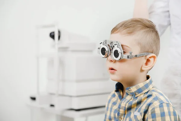 Enfant médecin d'accueil ophtalmologiste sélectionne des verres de lentille, vérifier la vue des yeux . — Photo