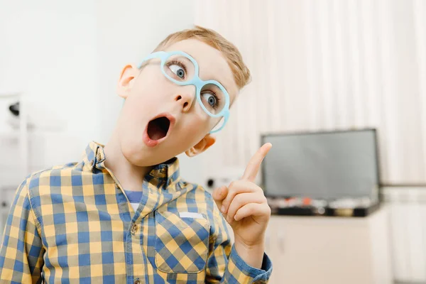 Enfant garçon est venu avec l'idée, doigt pointe des lunettes pour la vue devant les yeux . — Photo