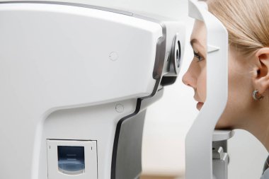 Genç kadın Resepsiyon Doktor göz doktoruna göz görme kalitesini kontrol etmek için.