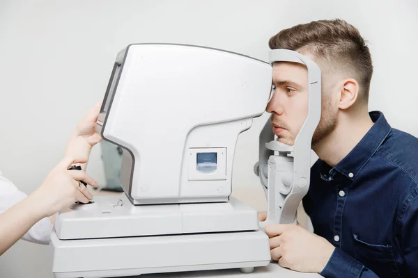 Kvinnliga läkare ögonläkare klinik kontrollerar öga vision av människan på maskin lampa. — Stockfoto