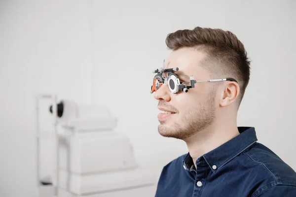 Oftalmologista mulher médico verifica diagnosticar miopia visão, hipermetropia homem jovem . — Fotografia de Stock