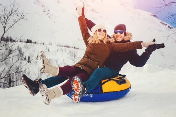 Gente feliz en el tubo al aire libre en las montañas en invierno nieve — Foto de Stock