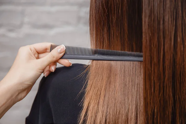 Master combs hair with his teeth in salon — Stock Photo, Image