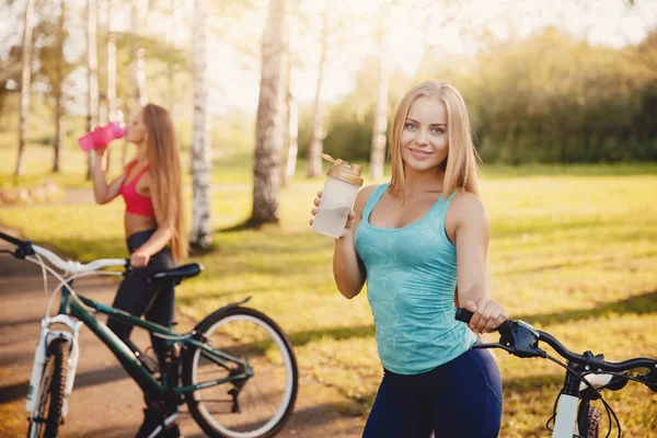 Mädchenfahrrad mit Wasserflasche im Park vor Sonnenuntergang — Stockfoto